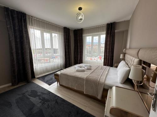 屈塔希亚Viyana Premium Pansiyon的一间卧室设有一张大床和两个窗户。