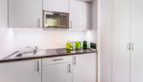 日内瓦N20 Residence by Homenhancement的白色的厨房配有水槽和微波炉