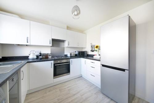 利物浦GuestReady - Humble Abode by Anfield Stadium的白色的厨房配有白色橱柜和冰箱。