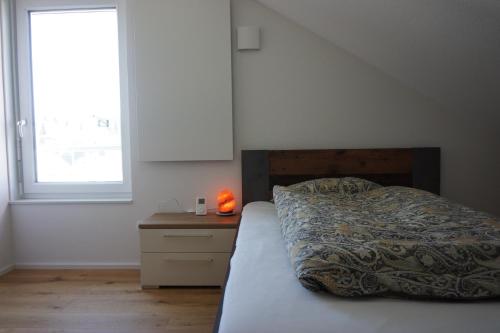 弗罗伊登施塔特Sonnenhalde Panoramablick的一间卧室配有床、床头柜和窗户