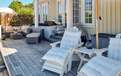 波什格伦Cozy Home In Porsgrunn With Heated Swimming Pool的庭院配有两把白色椅子和一张桌子