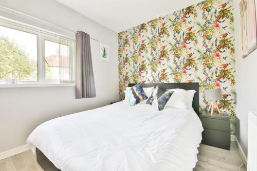 卡迪夫Garden Station Dwelling in Rumney的卧室配有白色床和花卉壁纸