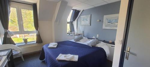 Troisvaux贝瓦尔酒店的酒店客房设有蓝色的床和窗户。