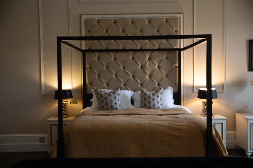比索普顿三月堂高尔夫Spa酒店的一间卧室配有一张大床和两盏灯