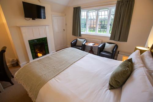 查姆斯特小法院酒店的卧室配有一张白色大床和壁炉