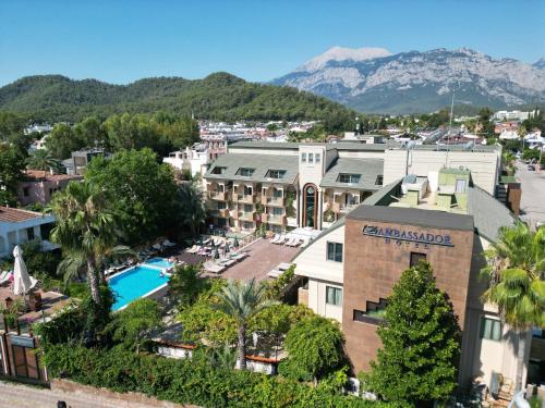 安塔利亚Ambassador Hotel & Spa- All Inclusive的享有带游泳池和山脉的度假村的空中景致