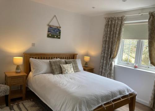 多诺赫Clashmore Wood的一间卧室配有一张床、两盏灯和一个窗户。