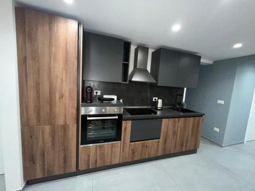 巴列塔San Giacomo Loft Apartment的厨房配有木制橱柜和炉灶烤箱。