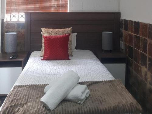克鲁格斯多普Cradle Mount Hotel的一间卧室配有一张带白色床单和红色枕头的床