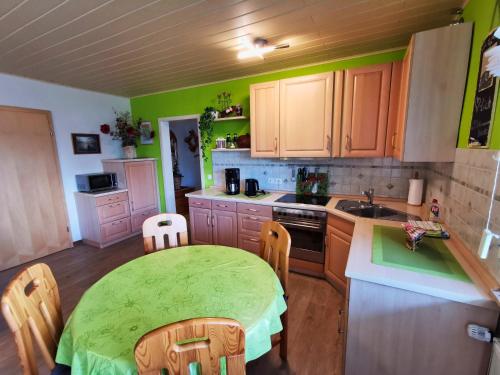 肖顿Zur schönen Aussicht的一间带桌子的厨房和一间带绿色墙壁的厨房