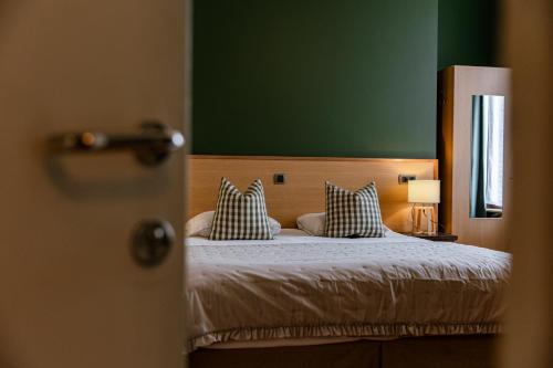 布鲁日马勒贝格酒店的一间卧室配有一张带两个枕头的床