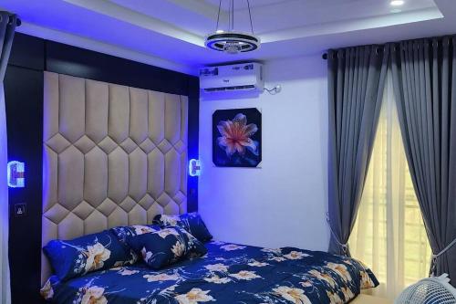 阿奴古MeTime Residence Enugu的一间卧室配有一张蓝色灯光的大床