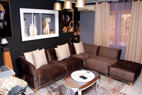 利伯维尔Villa Raissa 2的客厅配有棕色沙发和桌子