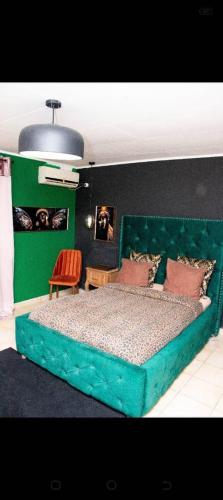 利伯维尔Villa Raissa 2的一间卧室配有一张绿色的床和绿色床头板