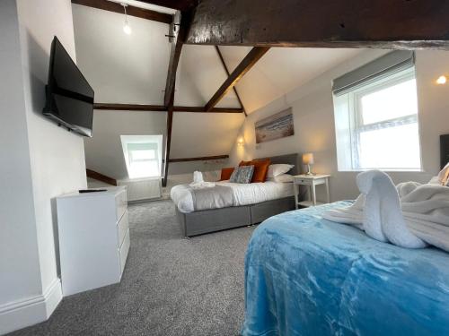 廷塔杰尔Tintagel Arms Bed and Breakfast的一间卧室配有两张床和一台平面电视