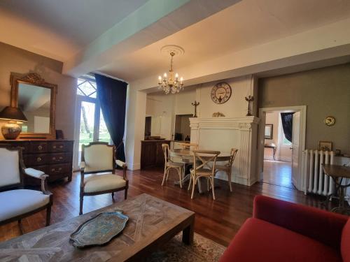 Saint-SulpiceLe Manoir du Thouron的客厅配有桌子和壁炉