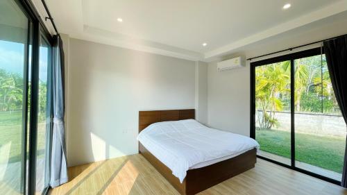 泰孟Spacious Private Villa Modern Style near beach的一间卧室设有一张床和一个大窗户