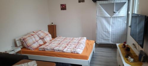 诺德豪森Ferienhaus Sonne的一间卧室配有一张带橙色毯子和窗户的床。