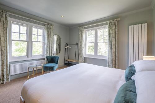 亨利昂泰晤士Flower Pot Hotel的一间卧室配有一张床、一把椅子和窗户。