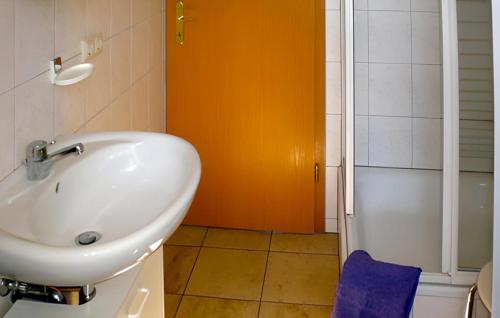 克林克Lovely Home In Klink With Kitchen的浴室设有白色水槽和橙色墙壁。