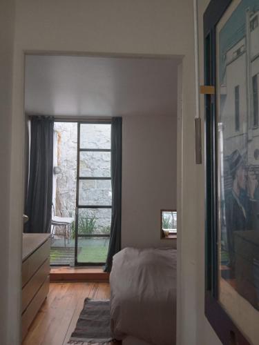 巴黎Paris, central et calme的一间卧室设有一张床和一个大窗户