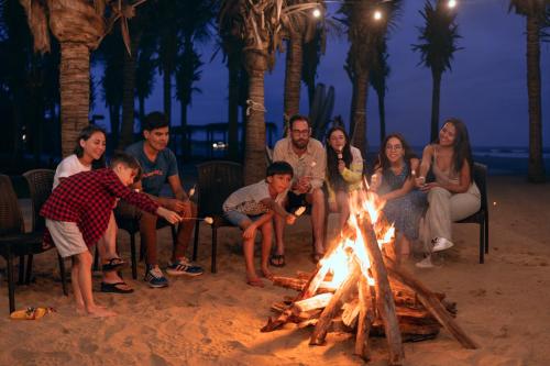 索里托斯索里托斯通贝斯安迪那精选度假村的一群人坐在海滩上的火堆旁