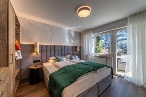 纳图尔诺Familien-Wellness Residence Tyrol的一间卧室设有一张大床和一个窗户。