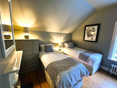 文特诺Belverdere Cottage - Pet friendly的一间带两张床和梳妆台的卧室