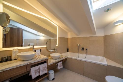 纳图尔诺Familien-Wellness Residence Tyrol的浴室配有两个盥洗盆和浴缸。
