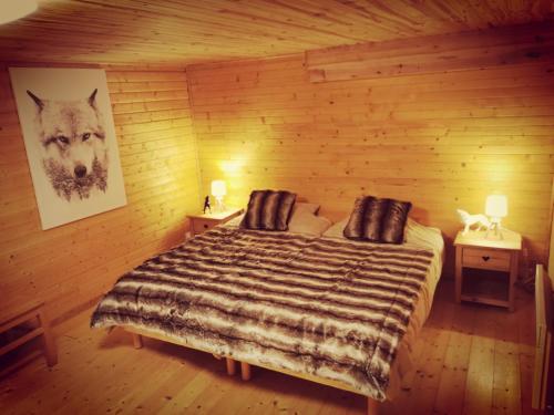 拉布雷斯The dream catcher -Spa- panoramic sauna- 2 MINUTES FROM THE SLOPES的木制客房内的一间卧室,配有一张床