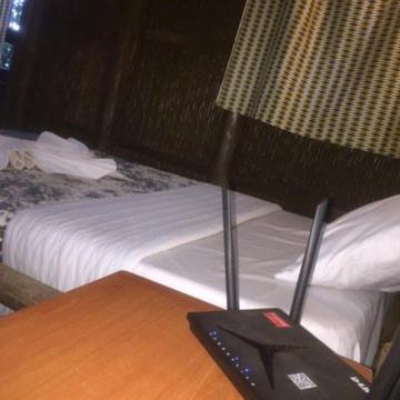 RwumbaIWACU ECO LODGE的一张桌子,床边有遥控器
