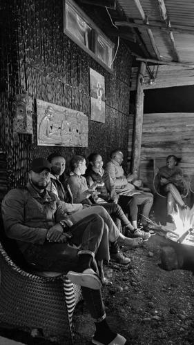 RwumbaIWACU ECO LODGE的一群人坐在火旁