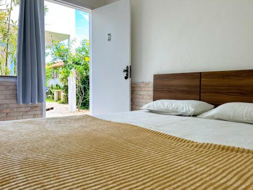 卡波布里奥IBELLO BEACH Pousada的一间卧室配有一张大床和木制床头板