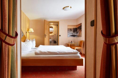 库罗阿尔滕堡拉登明勒酒店的酒店客房设有一张床和一扇门。