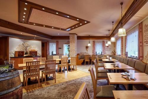 库罗阿尔滕堡拉登明勒酒店的餐厅设有木桌、椅子和窗户。