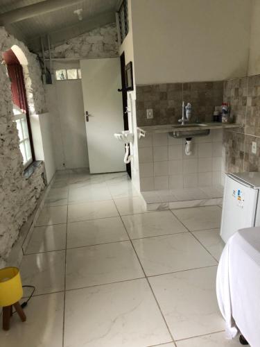 欧鲁普雷图Casa do Chá Ouro Preto的一间铺有白色大瓷砖地板的浴室和一间房间