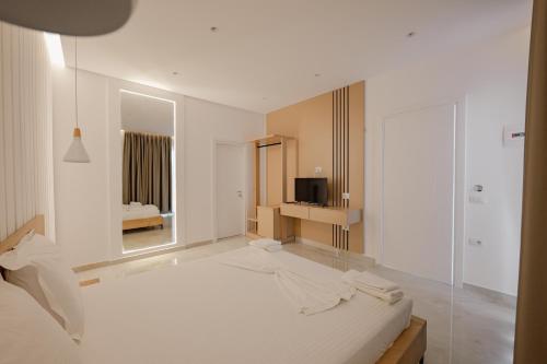 萨兰达Villa Xhefri的白色的客房配有床和电视