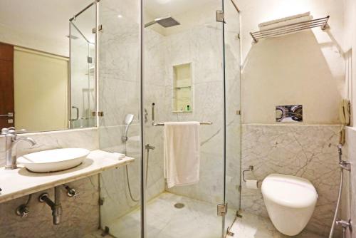 新德里Airport Hotel Claytone的带淋浴、卫生间和盥洗盆的浴室