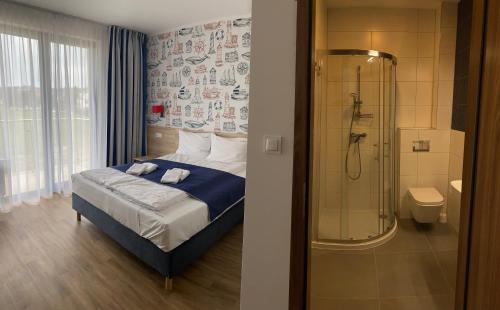 姆热日诺Faro Resort的带淋浴和床的卧室以及浴室。