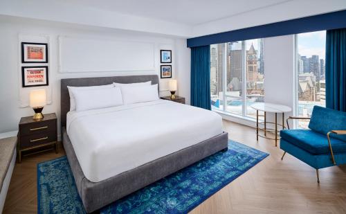 多伦多多伦多中心潘塔基斯酒店的一间卧室配有一张大床和一张蓝色椅子