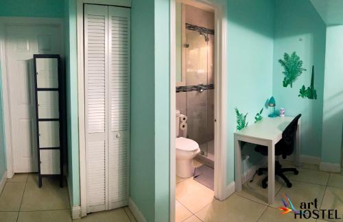迈阿密Art Gardens Wynwood concept的一间带卫生间和水槽的浴室以及一张书桌。