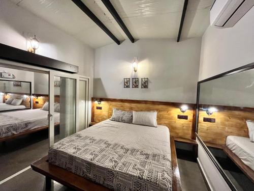 蓬蒂切里Mermaid Island Beach Resorts的一间卧室设有两张床和玻璃墙