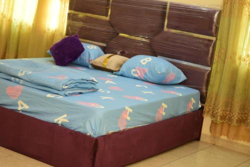 ZariaRoyal suites and Apartments的一张带蓝色棉被和枕头的床