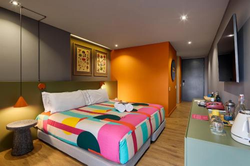麦德林Versus Hotel的一间卧室配有一张大床和一个柜台。