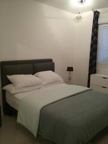 博韦Appart'hôtel的一间卧室配有带白色床单和枕头的床。