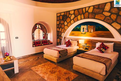 阿布辛贝塞提阿布辛贝湖度假酒店的酒店客房带两张床和一个大石墙
