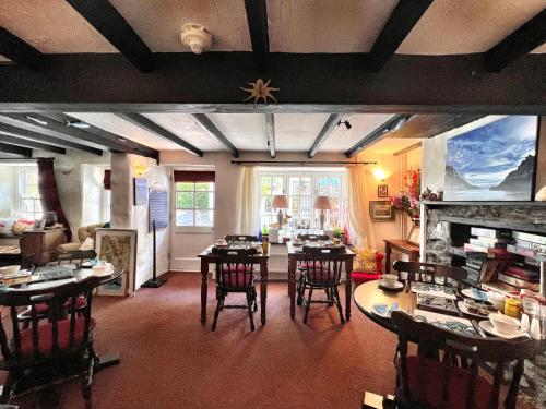 波尔佩罗The Cottage Bed & Breakfast的客厅配有桌椅和壁炉