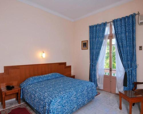 非斯靓彩酒店的一间卧室设有蓝色的床和窗户。