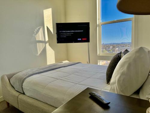 拉斯维加斯Ely on Fremont的卧室配有一张床铺,墙上配有电视