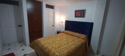 塔克纳HOTEL F0NTEs GLOBAL的一间卧室配有一张蓝色床头板的床
